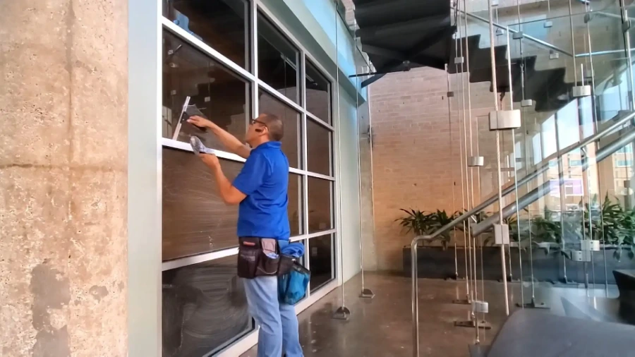 Professional window cleaner washing commercial windows