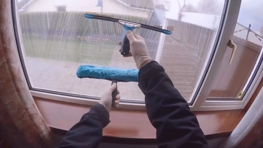 Squeegee and scrubber sleeve being used to clean an interior glass door
